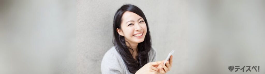スマホをもって笑顔の日本人女性