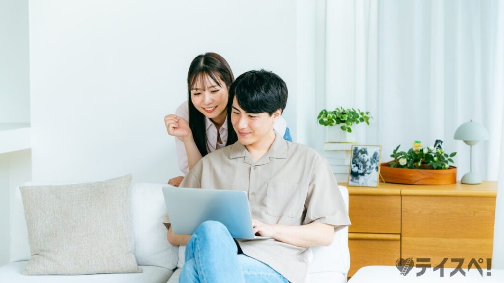 リビングでパソコンを見るカップル
