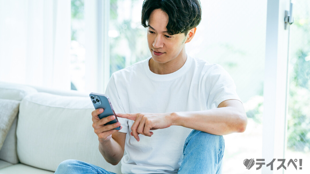 婚活アプリ「IBJ online」をスマートフォンで操作し、理想の結婚相手を探す男性の利用イメージ。