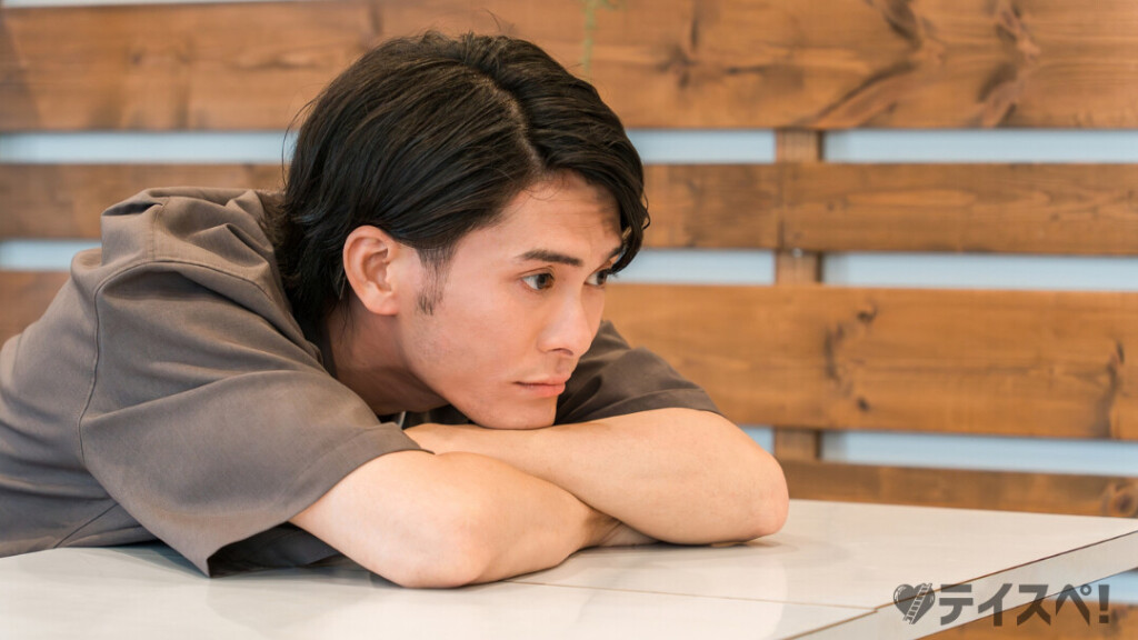 婚活パーティーでうまくいかないことに悩み、テーブルで考え込む男性の様子。