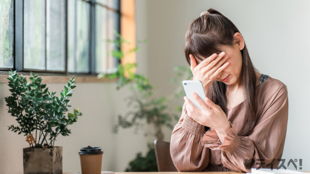 30代の婚活で「正解」が見つからず、スマートフォンの画面を見て落胆する女性。マッチングアプリや婚活の疲れを感じているイメージ。
